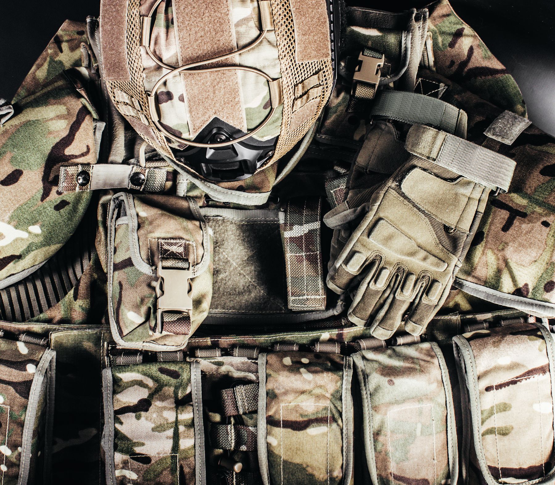 A plate carrier laid out with helmet, goggles, gloves and magazine pouches.