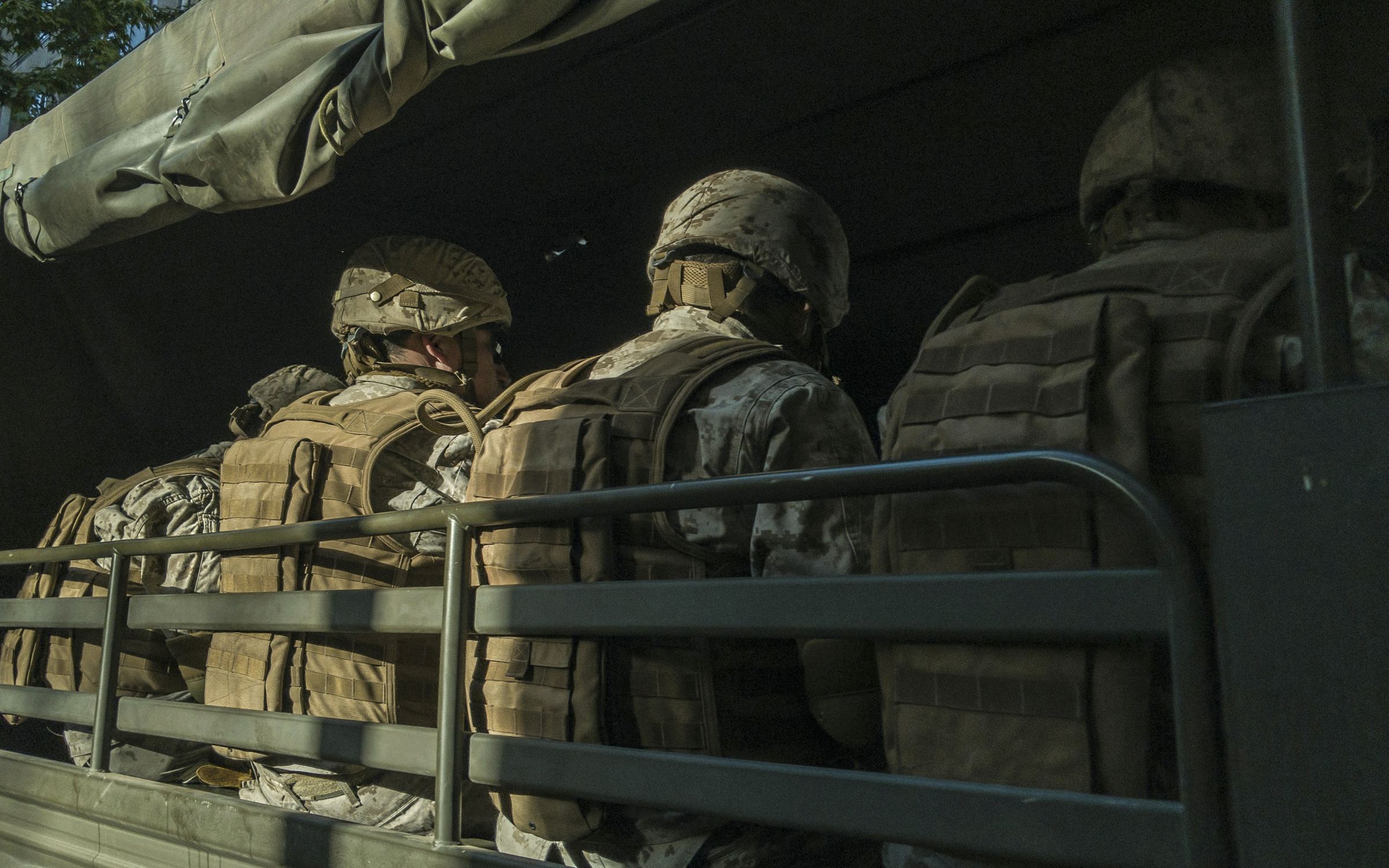 Soldiers riding in the back of a military truck